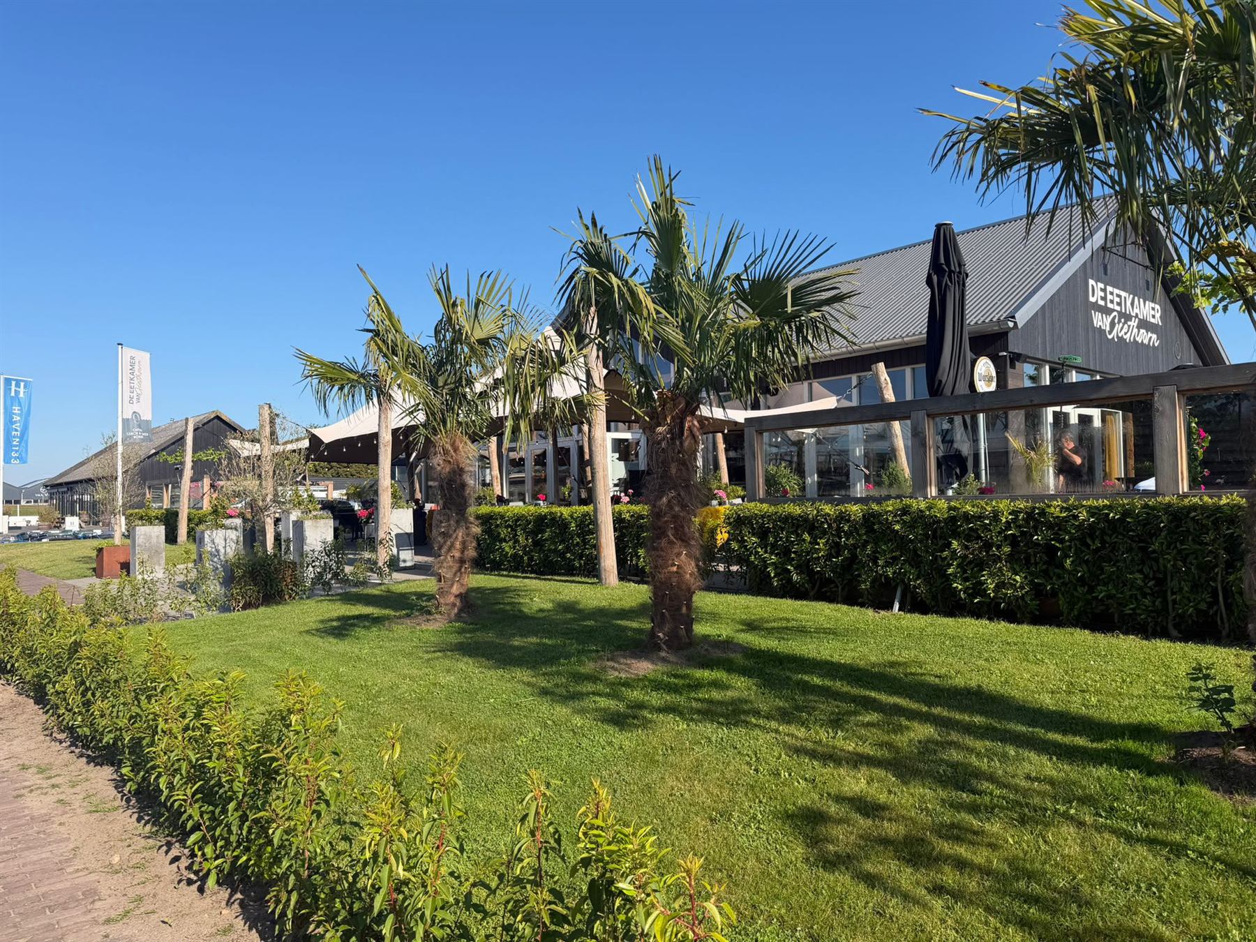 De gevel van De Eetkamer van Giethoorn met palmbomen