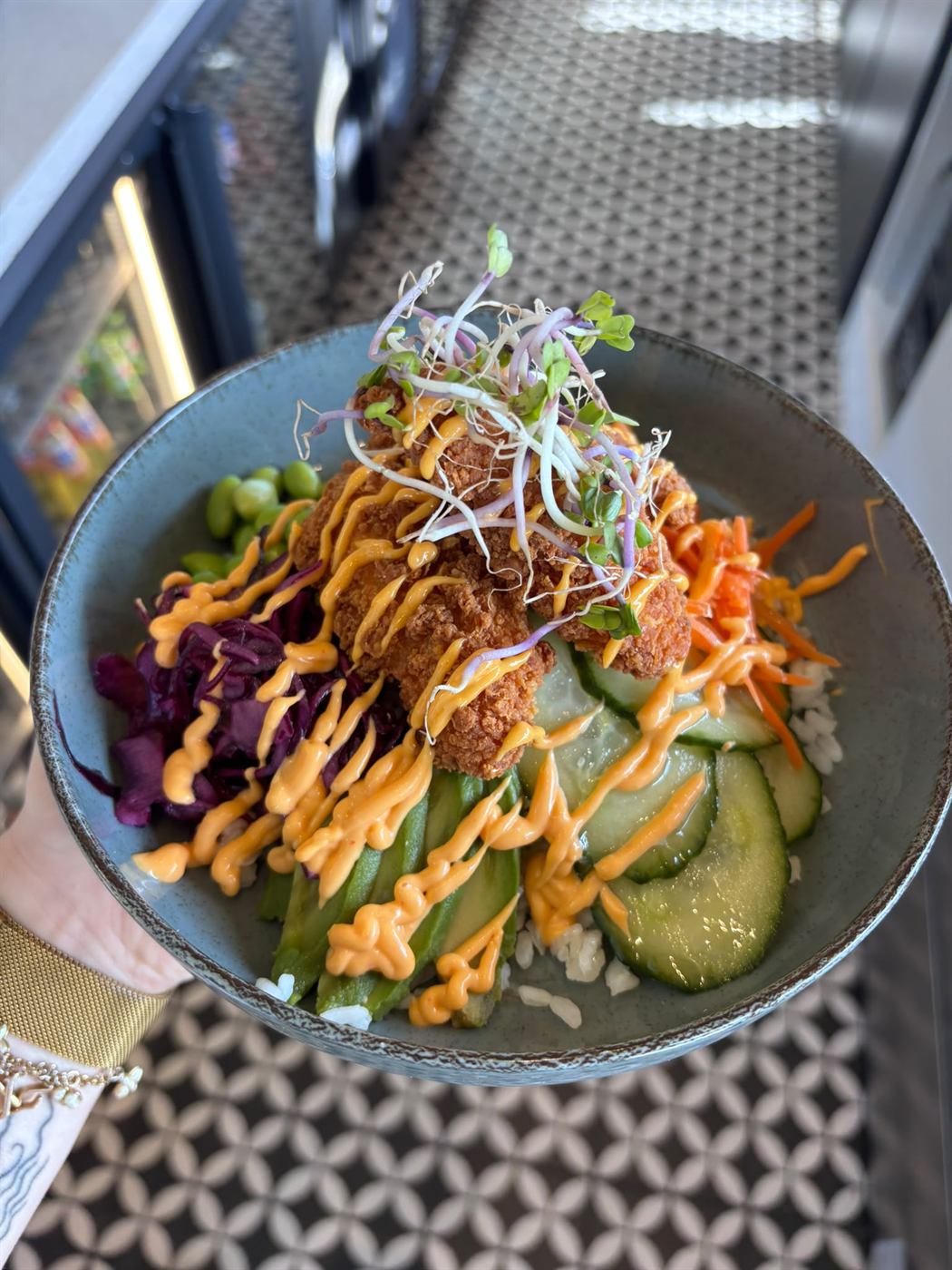 Bowl met krokante kip, rijst, komkommer en edamame